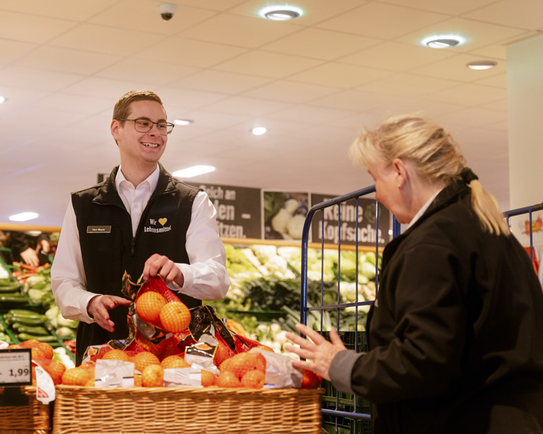 Obst, ein Verkäufer und eine Verkäuferin