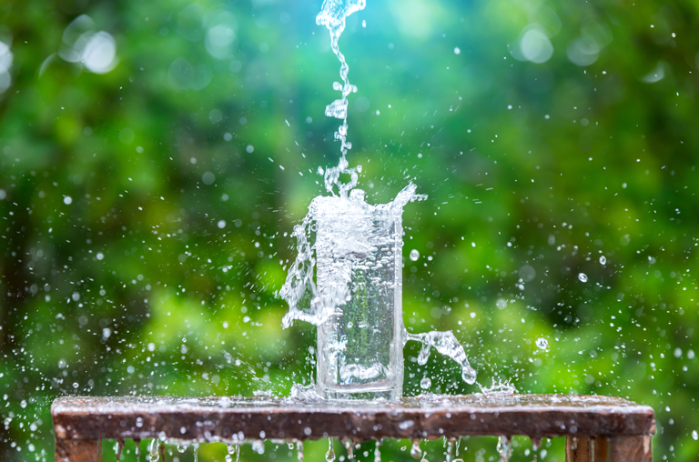 Wasser wird in Glas geschüttet