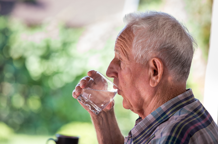 Älterer Herr trinkt Wasser